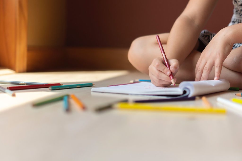 child writing on a notebook