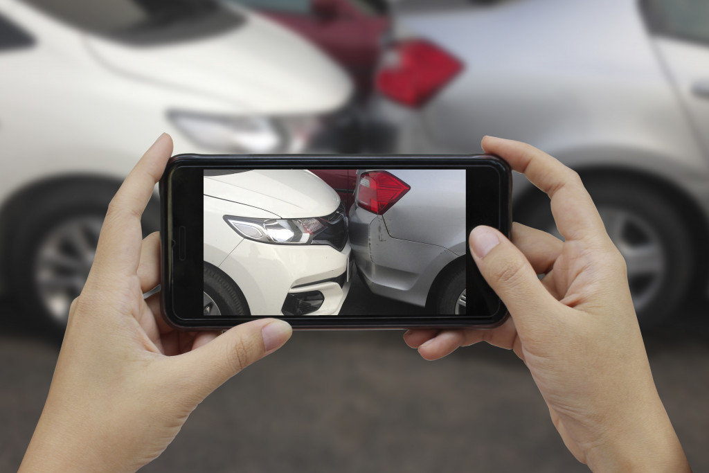 woman taking picture of car crash