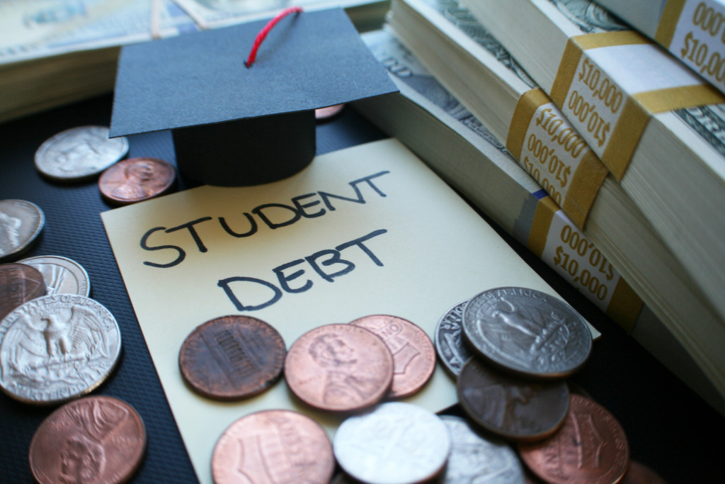 money and a piece of paper with "student debt" written on it