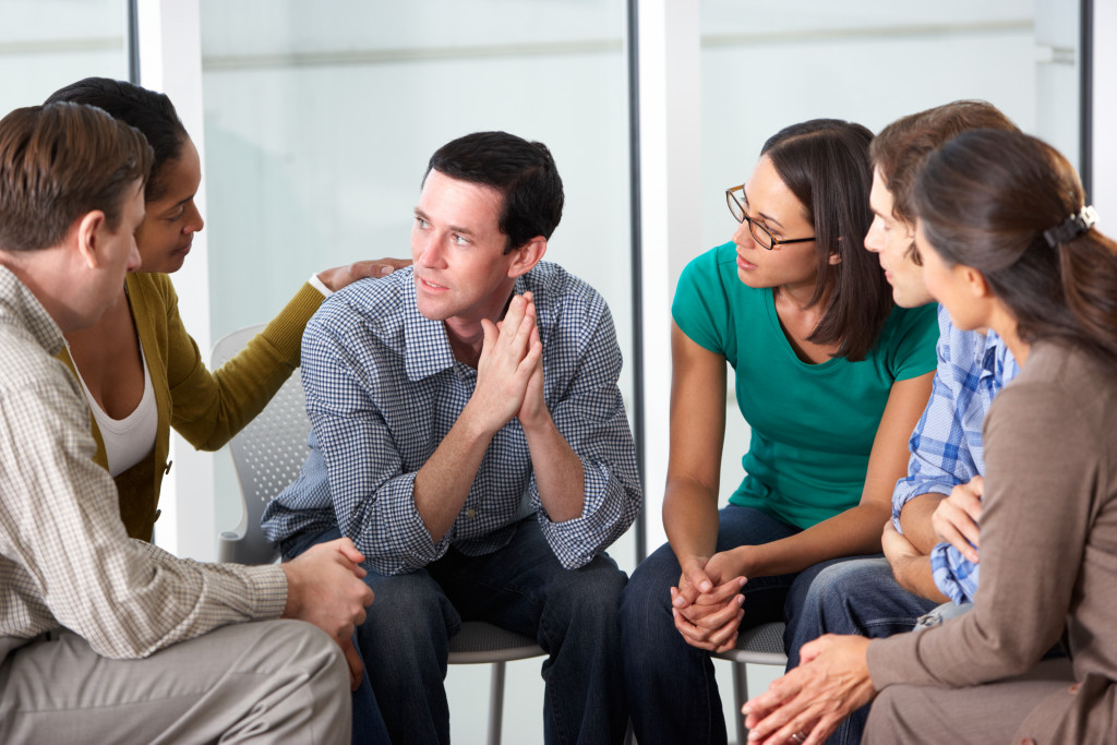A Man Talking to Members of A Support Group