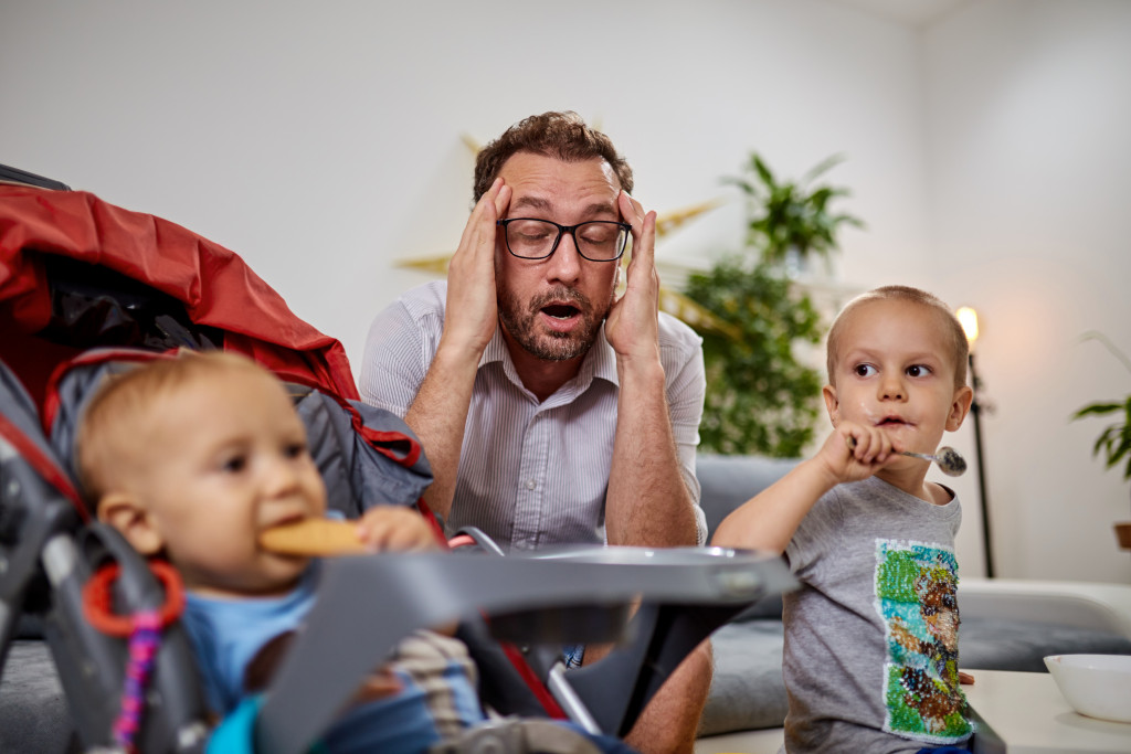 Stressed father with two young boys at home. 