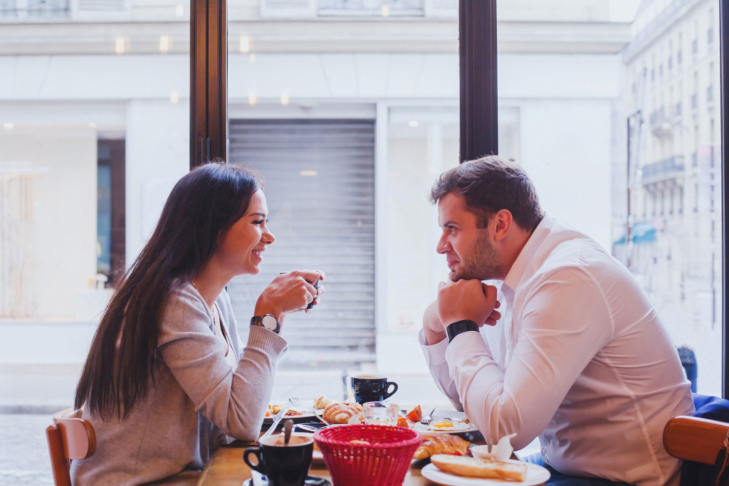 Couple talking with eat other while taking lunch.