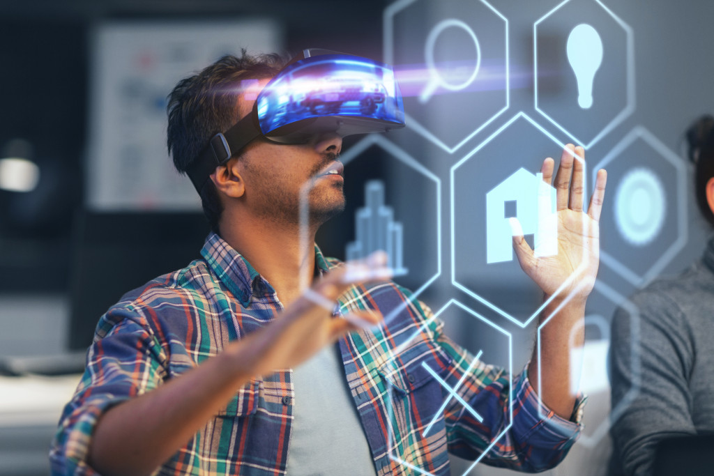 Man using VR goggles to work on a virtual screen in front of him.