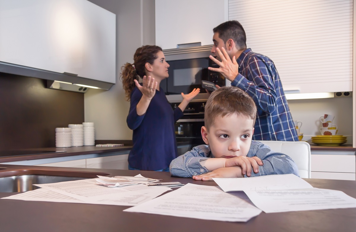 parents fighting behind small boy