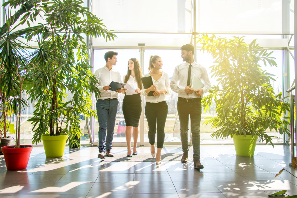 employee walking in the office lobby with plants around