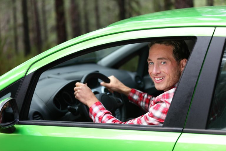 A man sitting in new green car enjoying trending tech features
