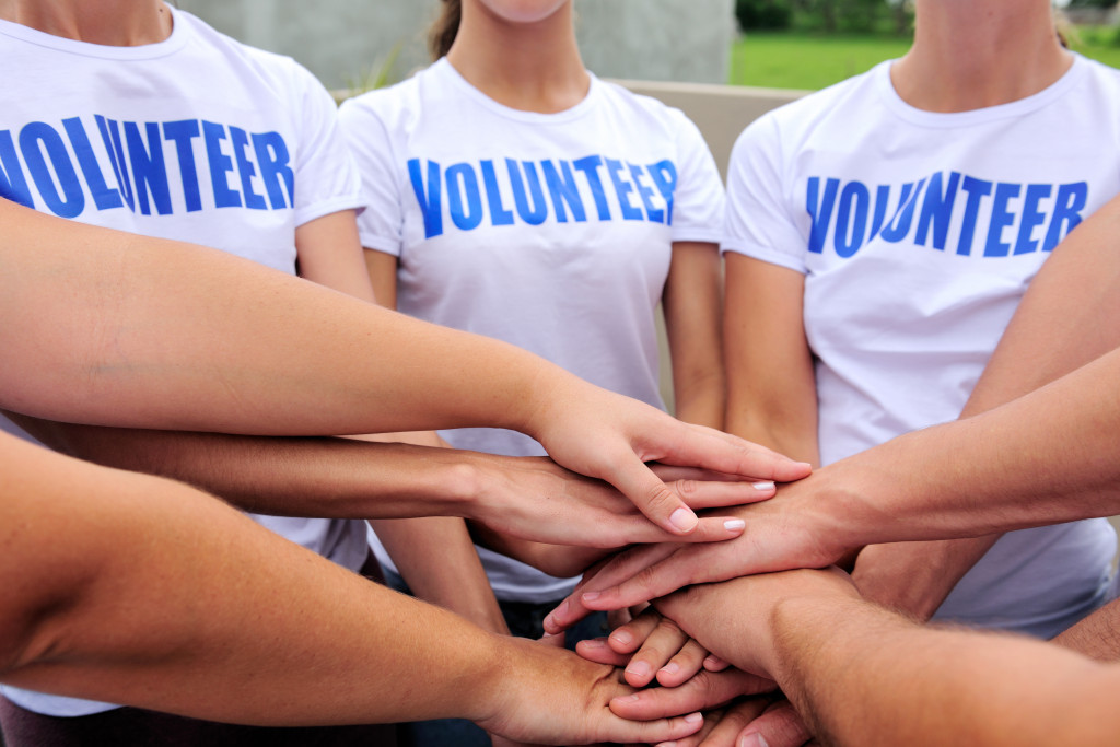 employees wearing a volunteer shirt with hands together