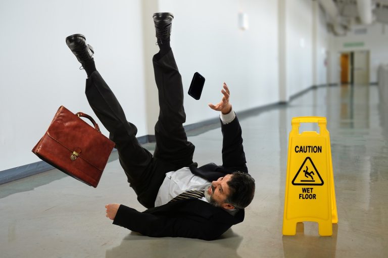 businessman falls in a slippery hallway