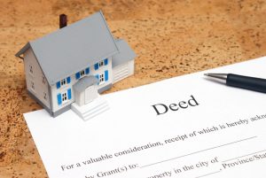 mini house beside a deed document