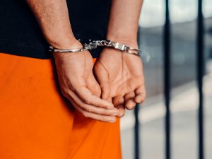 close-up of an incarcerated person's hands in handcuffs
