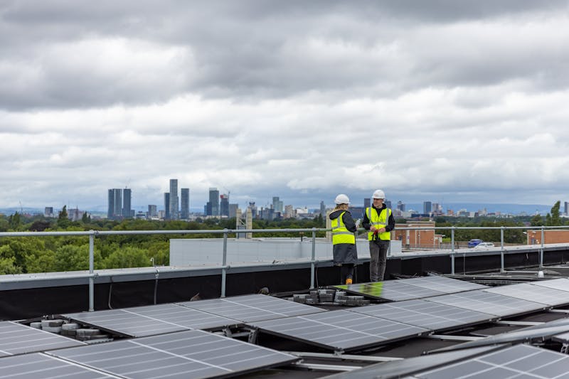 two people checking the solar panels